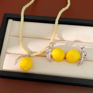 Detalle de un conjunto de joyas de limón con hojas de plata e incrustaciones de circón.