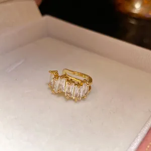 Macro detail of a 18k gold plated ear cuff with sparkling rectangular clear zircons