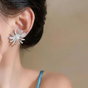 Detail view of fireworks-inspired zircon stud earring with pearl center on model