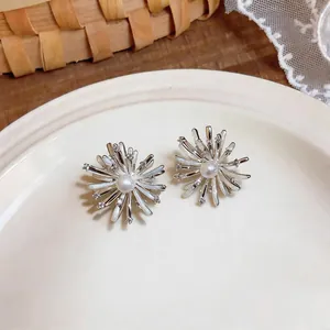 Close-up of elegant silver firework stud earrings with sparkling zircon and pearl accents