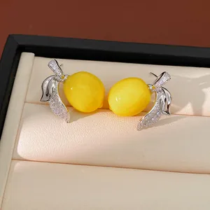Detalle de pendientes en forma de limón con pavé de circonitas en estuche joyero.