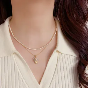 Dettaglio di un'elegante collana a doppio strato con perle e pendente a cesto fiorito