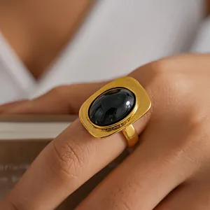 Detalle de anillo vintage dorado con gran piedra negra y un acabado envejecido