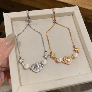 Dettaglio di braccialetti placcati in oro 14 carati con stelle e perle eleganti.