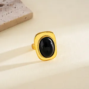 Anillo vintage dorado con piedra negra ovalada incrustada y textura de metal martillado.