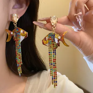 Detailansicht der übertriebenen Fischohrringe mit bunten Strassquasten und Kristallstecker.