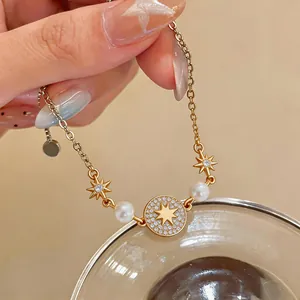 Dettaglio di un bracciale placcato oro 14k con zirconi a stella e perle eleganti.