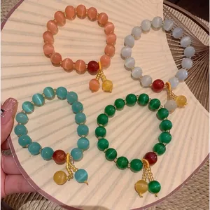 Set of four vintage cat eye stone beaded bracelets in vibrant colors with charms.
