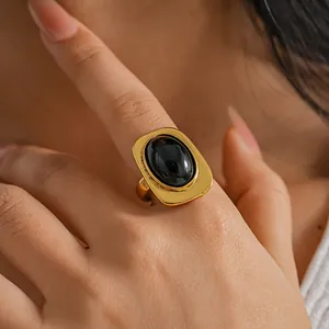 Primer plano detallado de un anillo dorado vintage ajustable con piedra negra ovalada