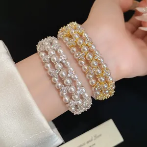 Close-up of multi-layer zircon and pearl beaded bracelets on wrist