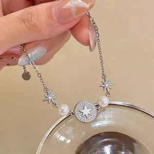 Primo piano di un elegante bracciale con stella, perle e zirconi cubici.