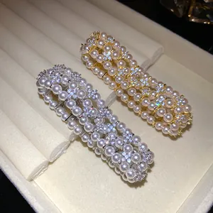 Detailed macro view of multi-layer pearl bracelets featuring zircon floral clusters.