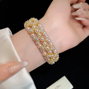 Detailed macro view of an elegant double-layer pearl bracelet with sparkling zircon flower accents