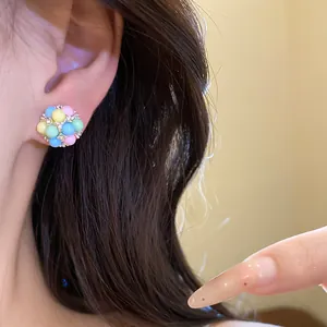 Gros plan d'une boucle d'oreille en grappe de perles pastel avec des accents de zircon