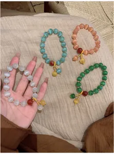 Close-up of elegant cat-eye beaded bracelets in four colors with decorative pendants