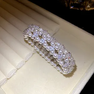 Close-up detail of multi-layer pearl bracelet with sparkling zirconia flower accents