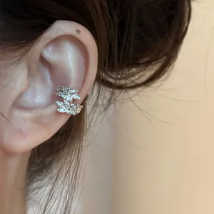 Close-up of sparkling zircon wheat leaf ear cuff worn on the ear cartilage detail