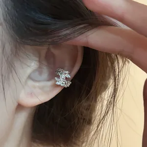Detailed close-up showing a silver wheat ear cuff with sparkling zircon inlay on ear.