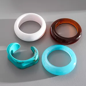 Dettaglio di bracciali in resina colorata con trame marmorizzate e tinte unite