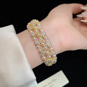 Detail showing triple-strand pearl bracelet with sparkling zircon flower accents on a wrist