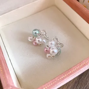 Vue détaillée de boucles d'oreilles nœud élégantes avec perles colorées et zircons.