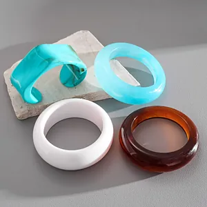 Primo piano di eleganti bracciali in resina marmorizzata e polsino geometrico