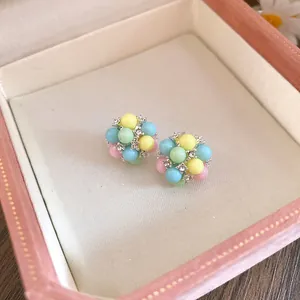 Gros plan de boucles d'oreilles en perles macaron avec zircons dans une boîte rose élégante