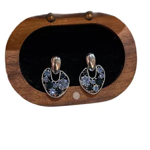 Elegant retro hollow stud earrings featuring blue sparkling crystals in a wooden box