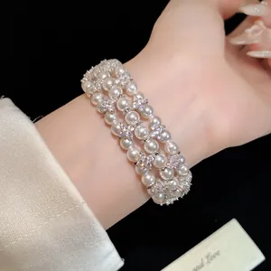 Detailed view of elegant multi-layer pearl bracelet with zircon flower accents.