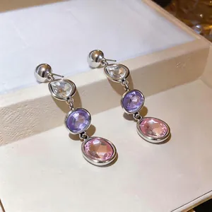 Elegant silver-toned long drop earrings with clear, purple, and pink faceted gemstones