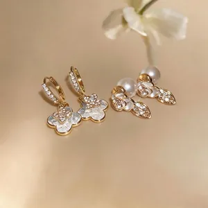Elegant gold-tone earrings featuring mother-of-pearl clover and rose pearl designs