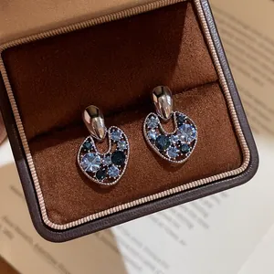 Close-up of vintage hollow earrings with blue rhinestones in a luxury jewelry box