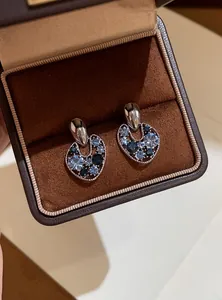 Macro detail of vintage irregular hollow stud earrings with blue sparkling crystals