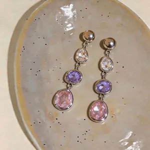 Elegant long silver geometric drop earrings featuring clear, purple, and pink faceted stones