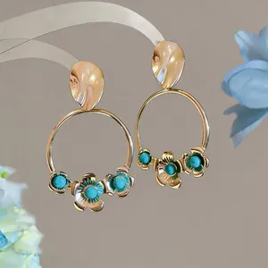 Detail view of vintage French gold hoop earrings featuring elegant floral turquoise accents