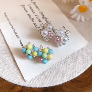 Gros plan de boucles d'oreilles perles nœud et grappes colorées sur carte support