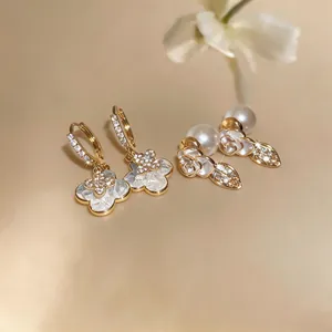 Detail view of elegant gold-plated flower earrings with sparkling rhinestones