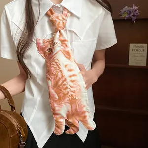 Détail d'un collier cravate original avec imprimé chat porté sur une chemise blanche