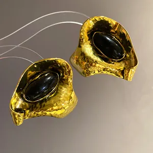 Vue macro de boucles d'oreilles vintage dorées avec de grands centres en résine noire