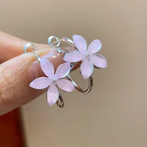 Detailed macro shot of elegant light pink resin flower charms on silver-tone hoop earrings