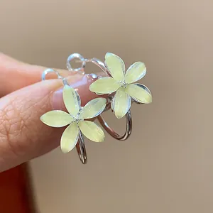Detail view of yellow resin flower hoop earrings with shimmer effect