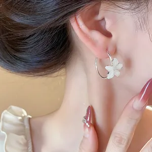 Elegant silver needle resin flower hoop earrings worn by a model for a close-up shot
