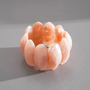Detail of peach marbled acrylic bracelet with smooth petal-shaped links.