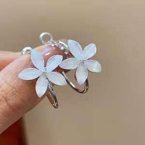 Detailed macro shot of white resin flower hoop earrings with elegant silver finish