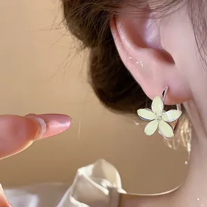 Close-up of elegant Korean resin flower hoop earrings worn on a model's ear.
