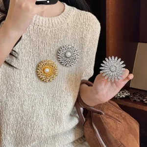 Broches fleurs étincelantes en zircon et perle pour femme sur un pull en maille beige