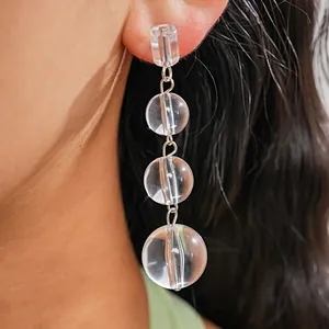 Vue rapprochée de boucles d'oreilles pendantes en cristal portées par un mannequin