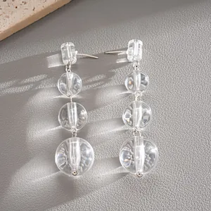 Gros plan sur boucles d'oreilles pendantes en perles de cristal avec clous en argent