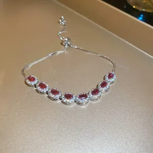 Primer plano detallado de una elegante pulsera ajustable con circonitas rojas óvalo