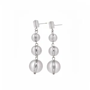 Boucles d'oreilles pendantes triple boules argentées avec bandes pavées de cristaux.